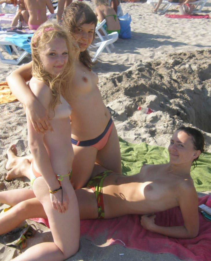 Amateurs girl topless group shot on the beach 