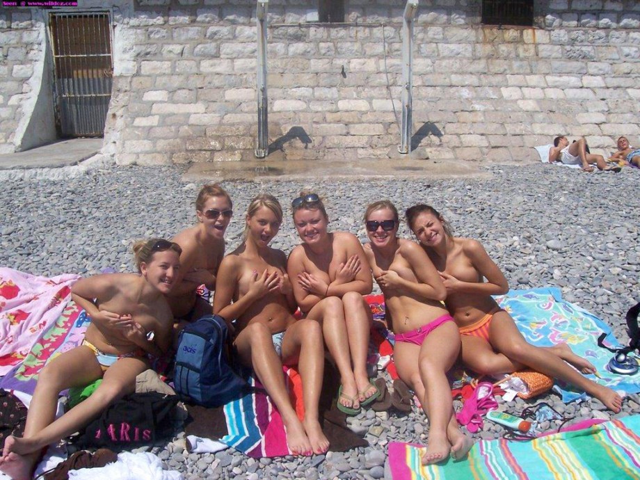 Amateurs girl topless group shot on the beach 