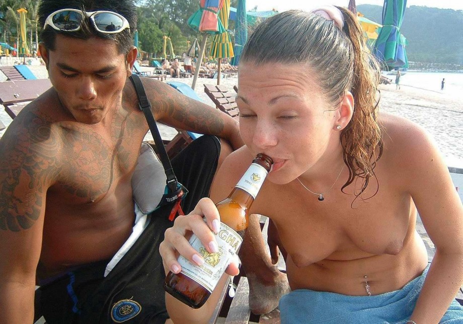 Nudist girls take a drink at the beach 