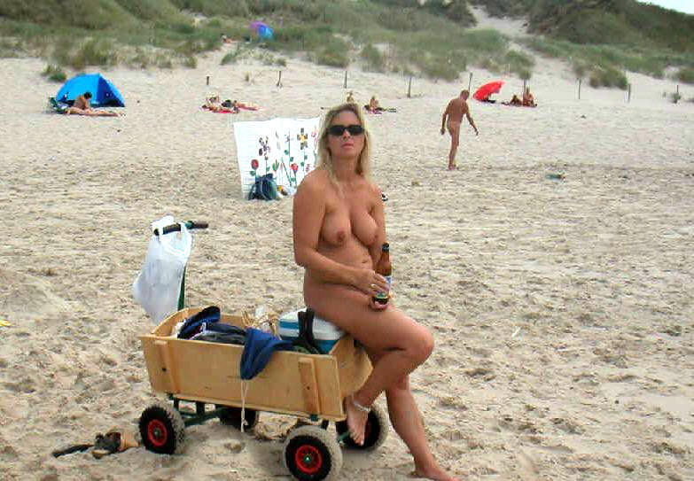 Nudist girls take a drink at the beach 