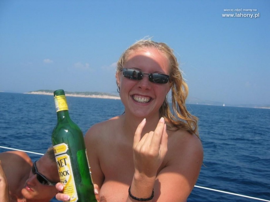 Nudist girls take a drink at the beach 