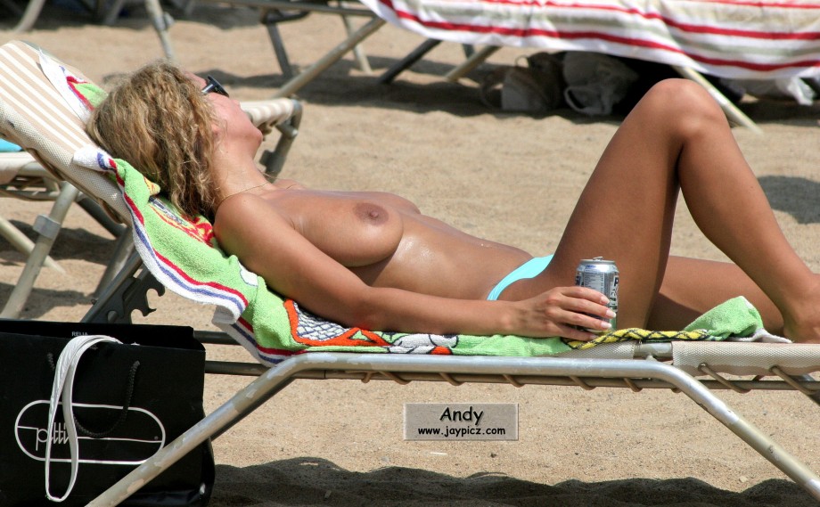 Nudist girls take a drink at the beach 