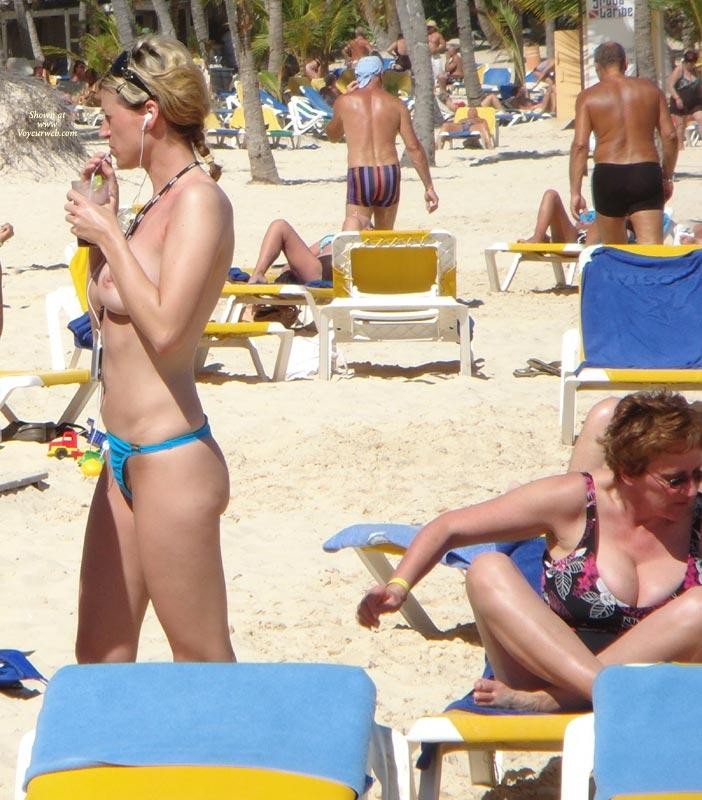 Nudist girls take a drink at the beach 