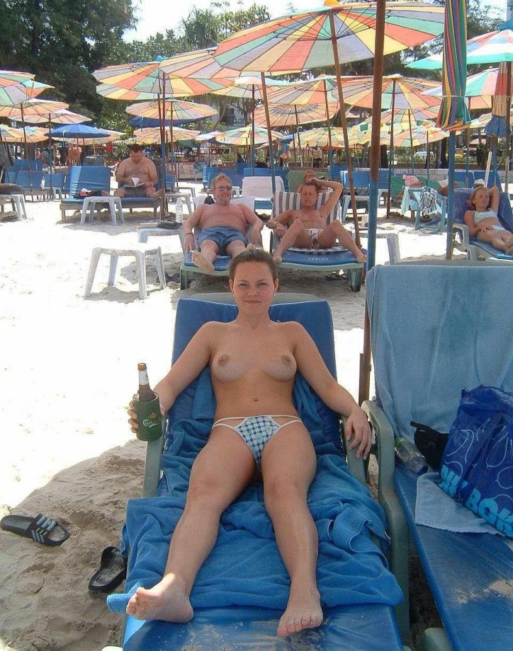 Nudist girls take a drink at the beach 