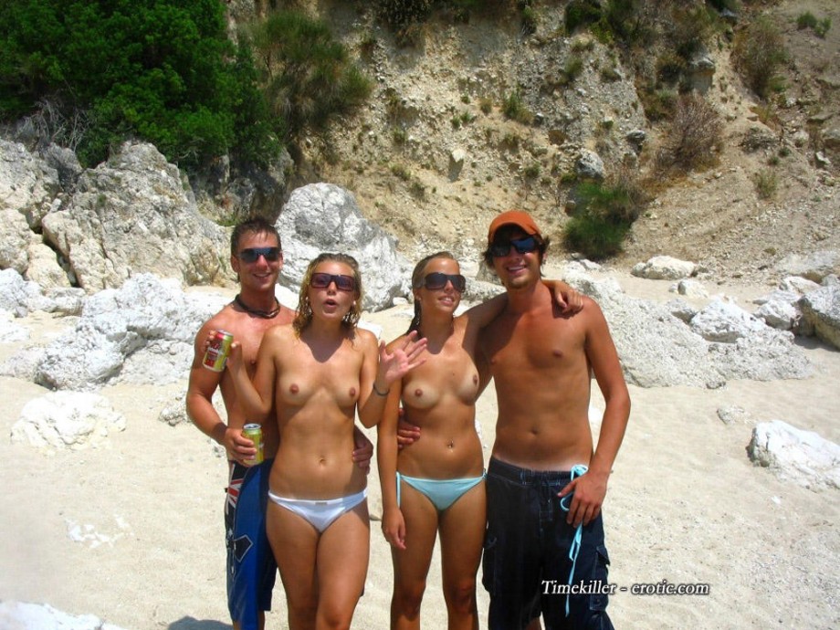 Nudist girls take a drink at the beach 