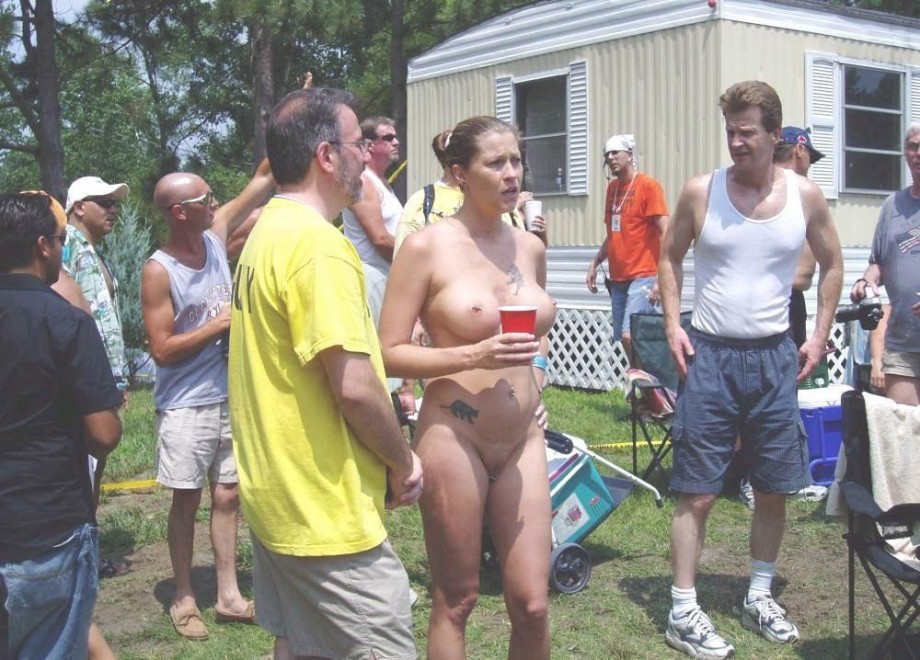 Nudist girls take a drink at the beach 