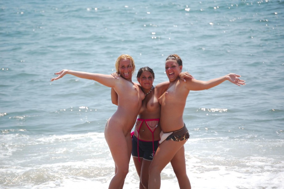 7 girls topless group shot on the beach 