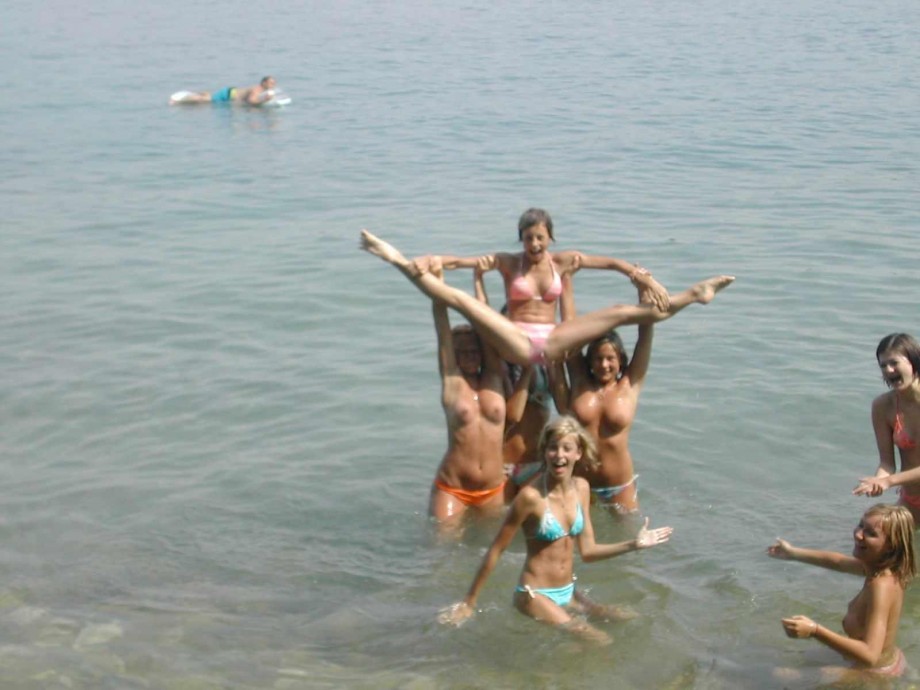 7 girls topless group shot on the beach 