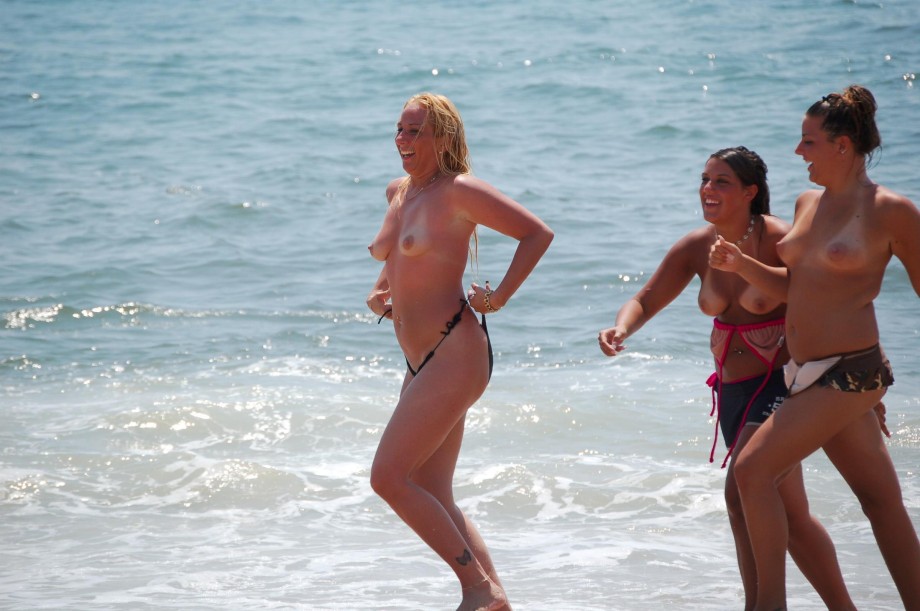 7 girls topless group shot on the beach 