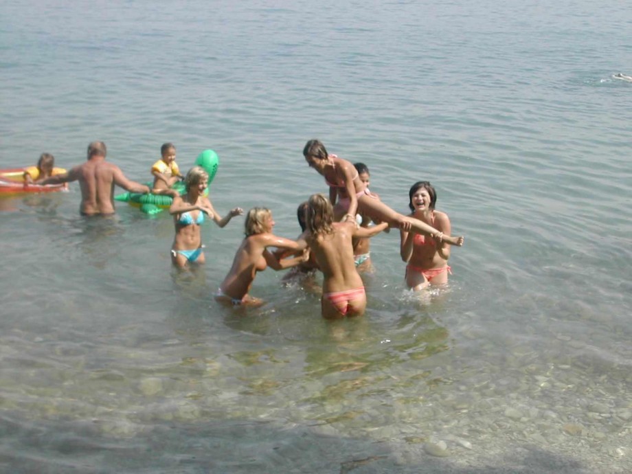 7 girls topless group shot on the beach 