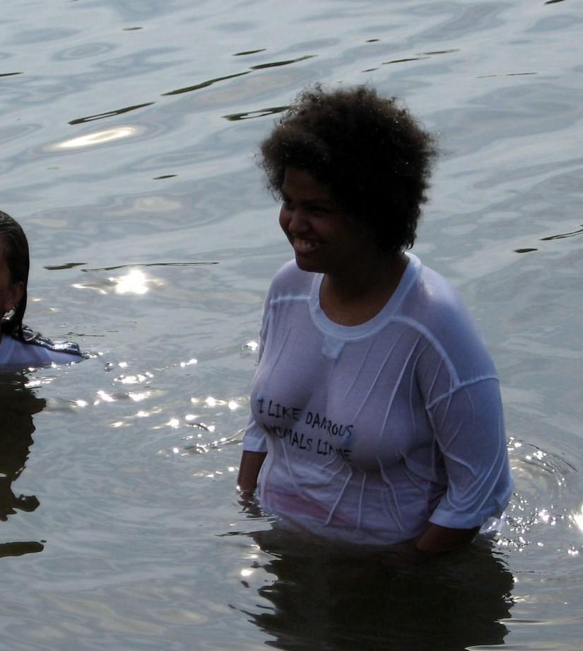 Funny girls on lake in wet shirts