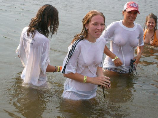 Funny girls on lake in wet shirts