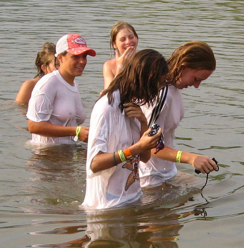 Funny girls on lake in wet shirts