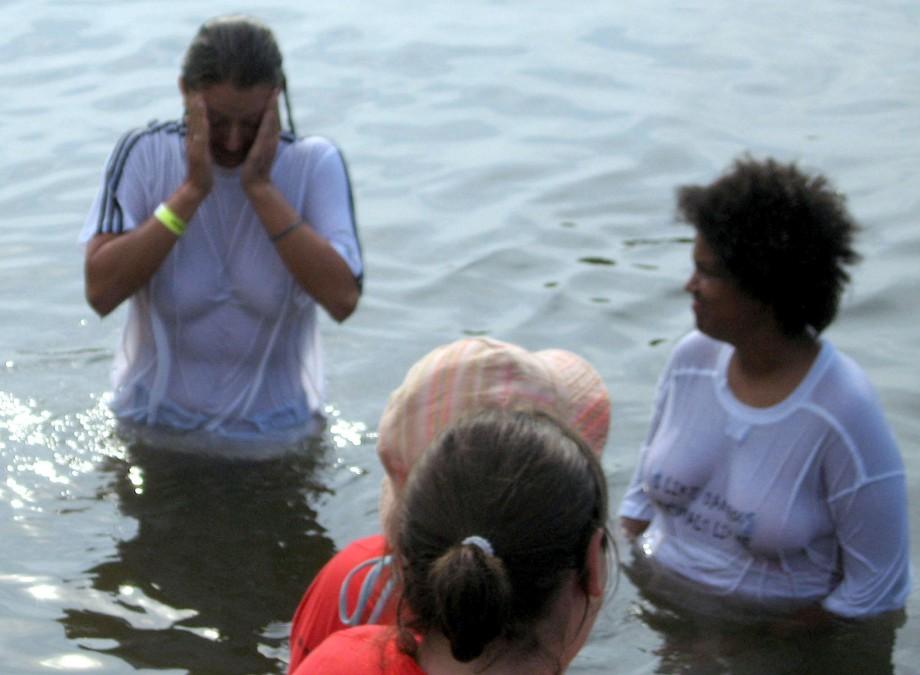 Funny girls on lake in wet shirts