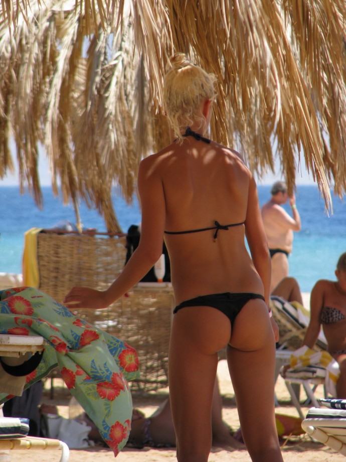 Blond beach girl problems with the bikini
