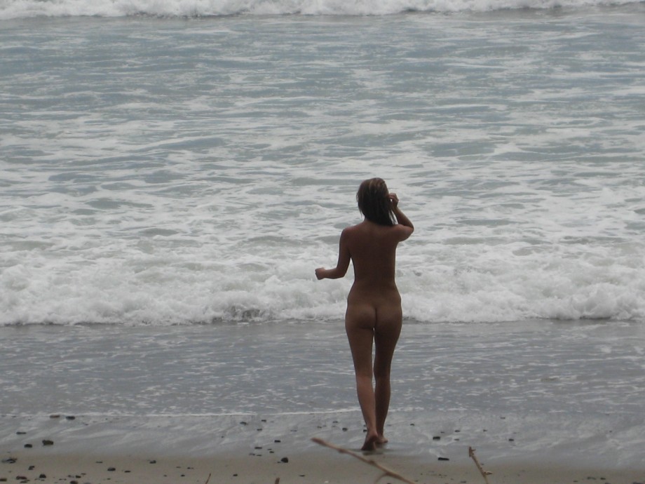 Brunette with pierced nipples on nudist beach