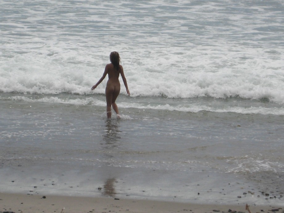 Brunette with pierced nipples on nudist beach