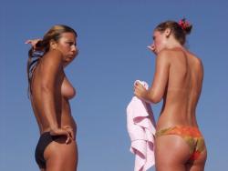 A couple of hot topless teens talking on the beach(7 pics)