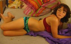 Incredibly hot brunette teen posing on a bed 10/26