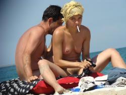 Nudist girl smoke on the beach 1/50
