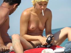 Nudist girl smoke on the beach 5/50