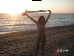 Brunette teen teasing on nude beach 8/46