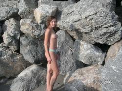 Brunette teen teasing on nude beach 13/46